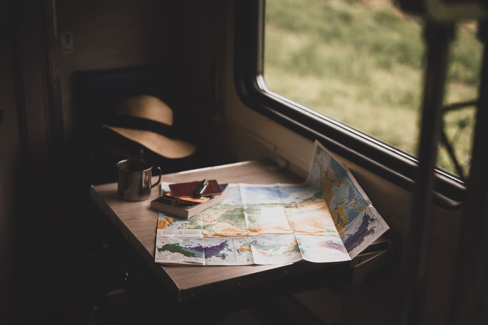 Table avec carte du monde, tasse et chapeau pour préparer un voyage