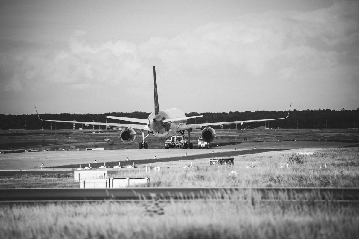 Avion positionné sur la piste d'atterrissage en photographie noir et blanc