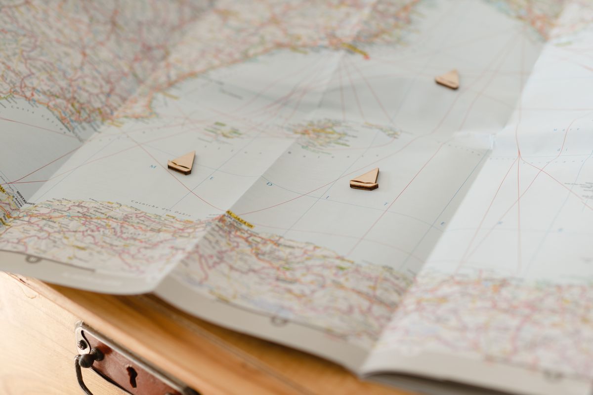 Carte du monde avec marqueurs navires en bois disposés sur une table
