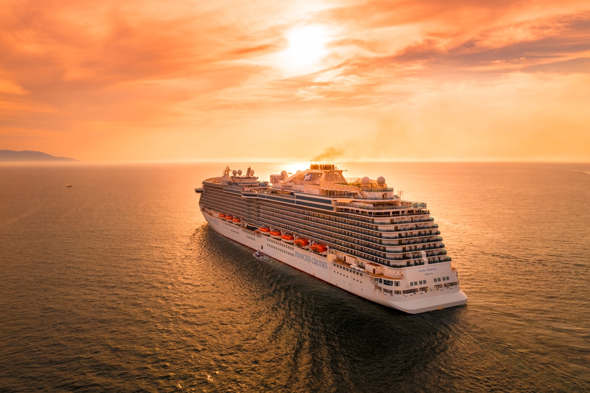 Navire blanc naviguant en mer durant le coucher de soleil.
