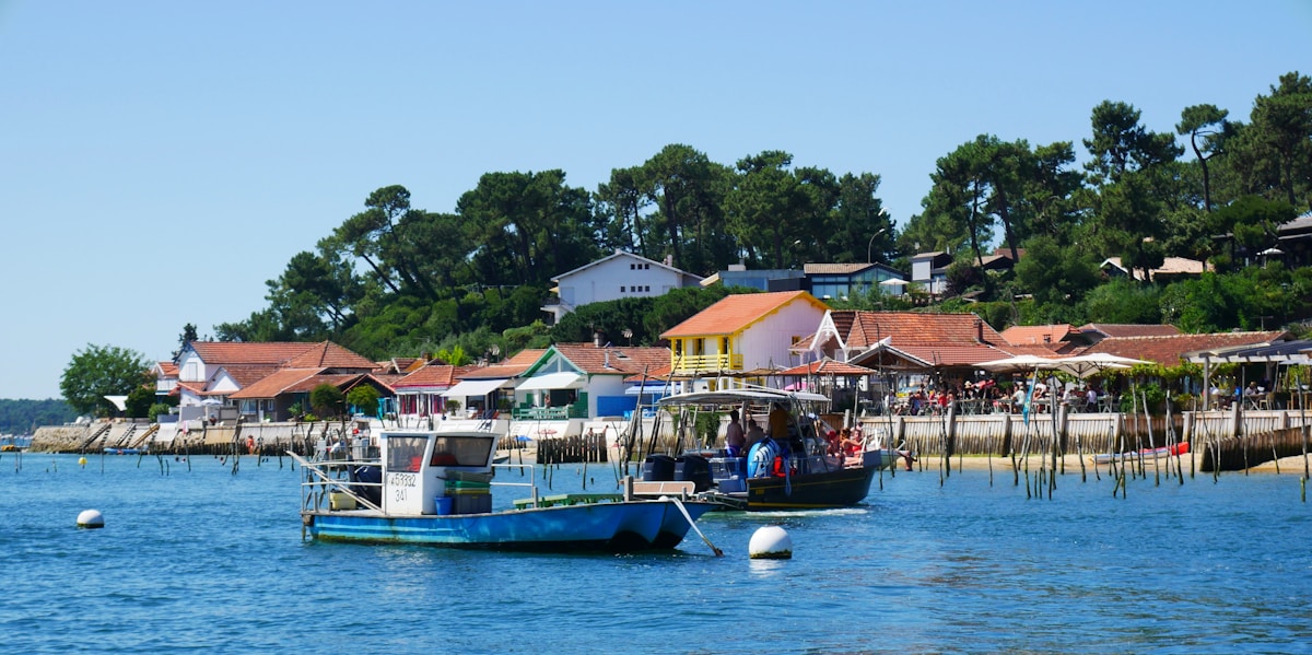 Village de pêcheurs avec bateau bleu et blanc sur le bassin d'Arcachon.